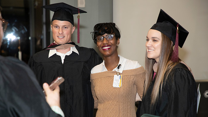 Students in commencement wear with professor